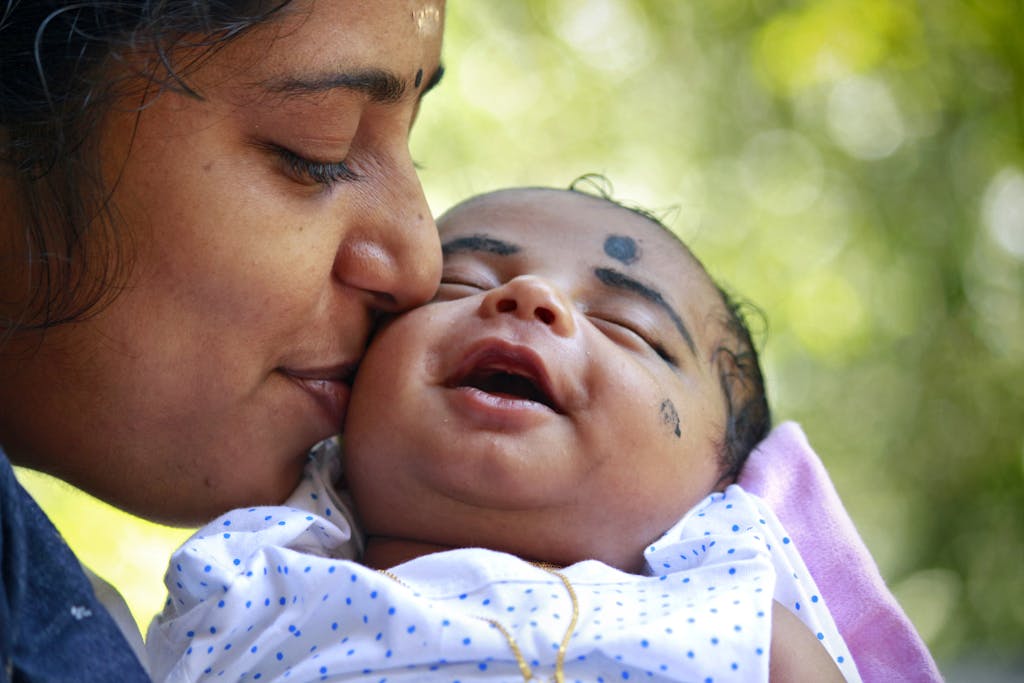 Close-Up Photo of Mother Kissing Her Baby