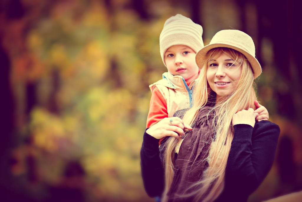 Shallow Focus Photo of a Woman Carrying a Toddler